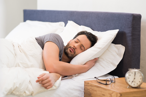 man sleeping comfortably in bed